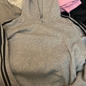 Gray adidas hoodie with black stripes up and down the sleeves